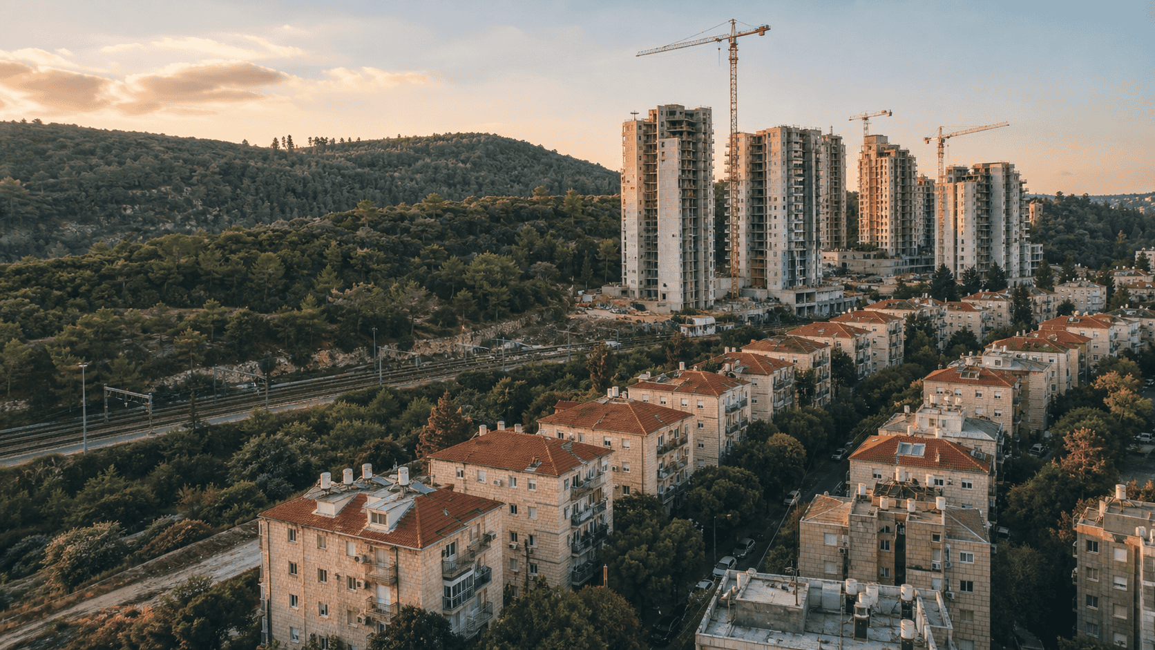 מבט על שכונה ותיקה בכרמיאל ומגדלי מגורים חדשים בבנייה ברקע, אילוסטרציה